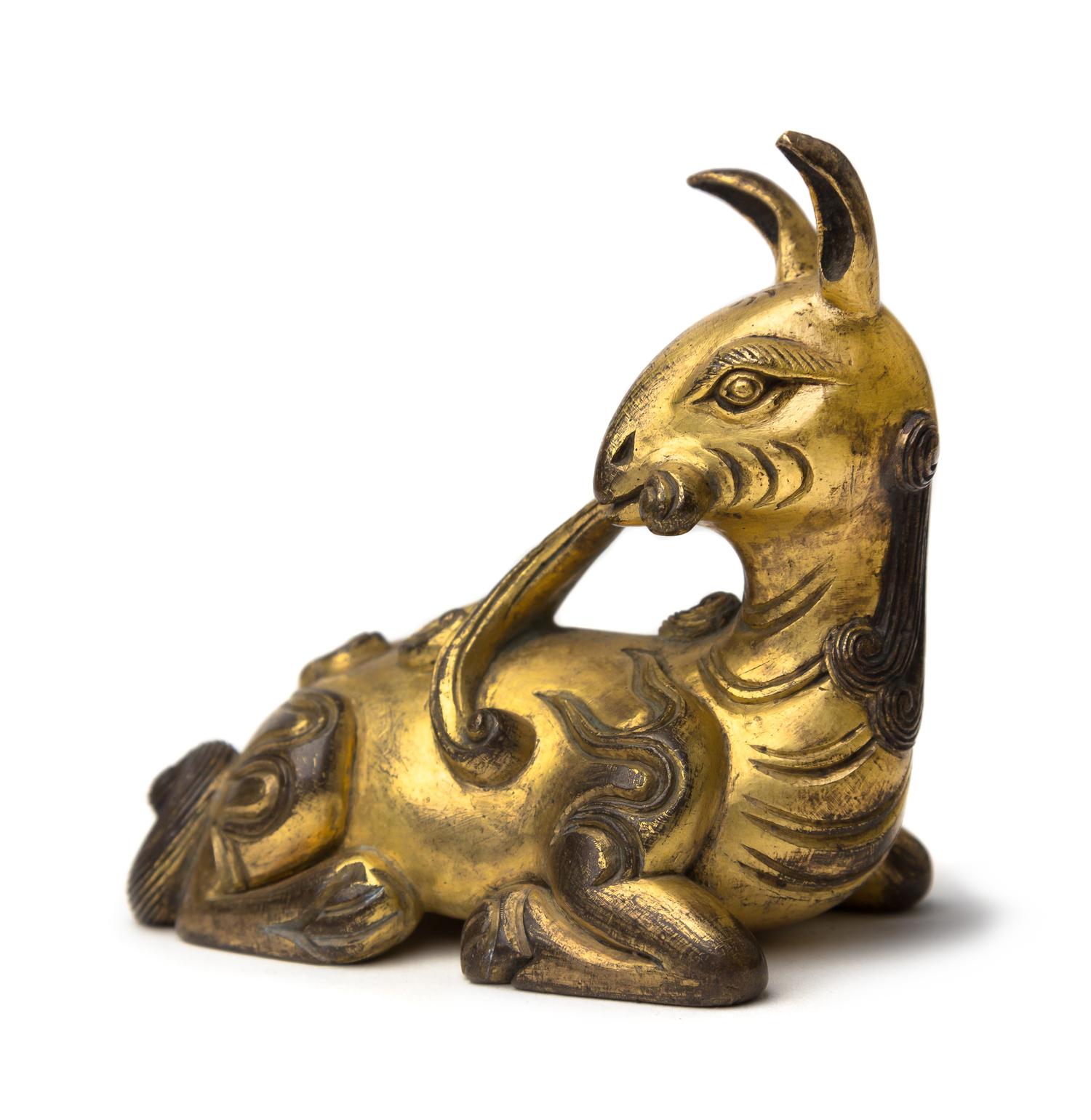 A Gilt Bronze Figure of a Recumbent Deer Height 2 7/8 inches. — MING DYNASTY (1368-1644)