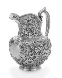 An American Silver Water Pitcher, J.E. Caldwell, Philadelphia, PA, the baluster form body having repousse floral and foliate decoration