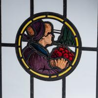 Stained glass window depicting man with basket of apples