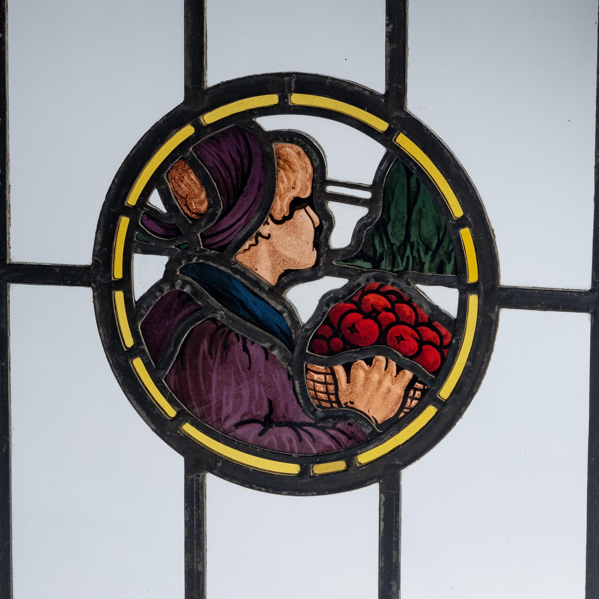 Stained glass window depicting man with basket of apples