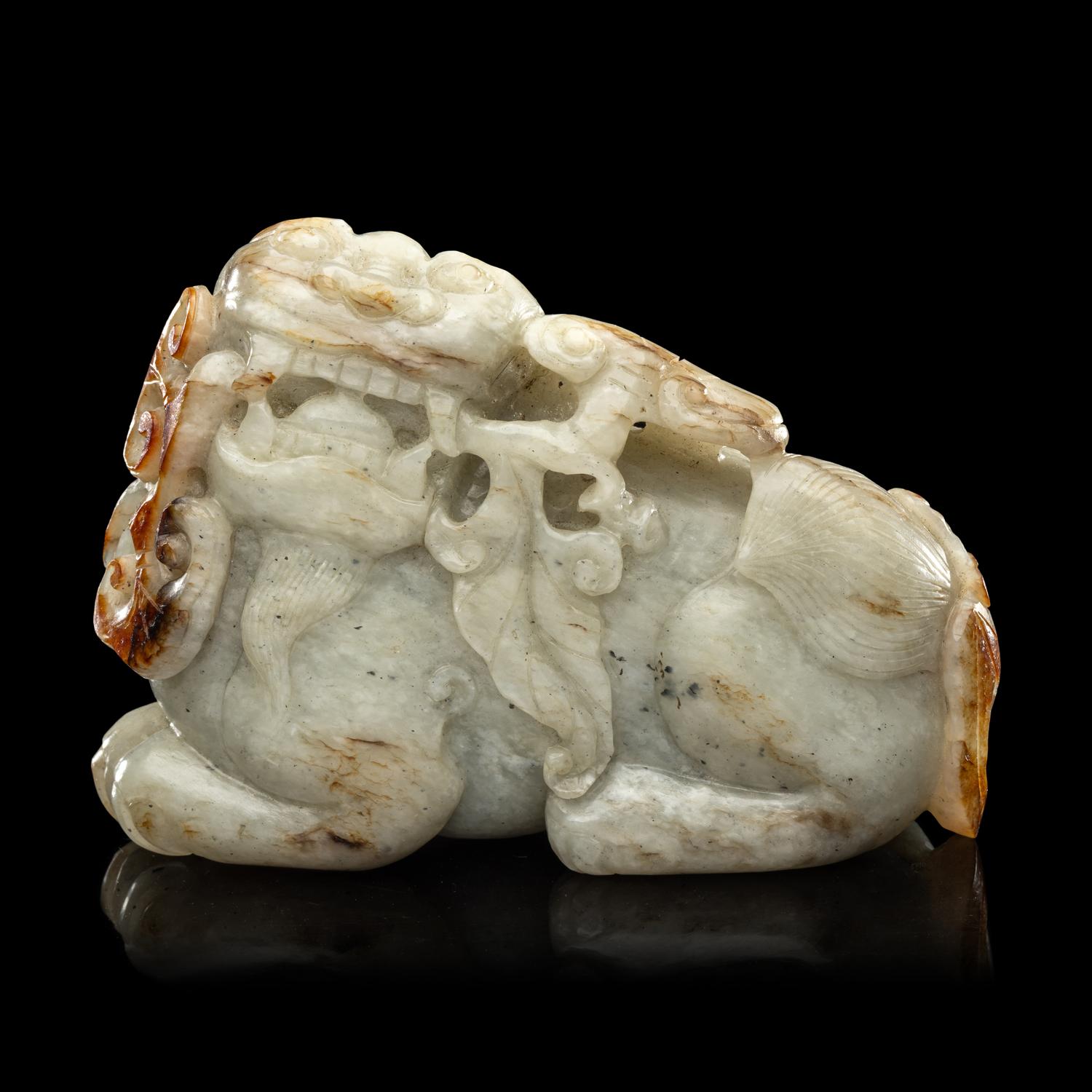 A Chinese Russet and Greyish Celadon Jade Figure of a Recumbent Qilin 青玉麒麟