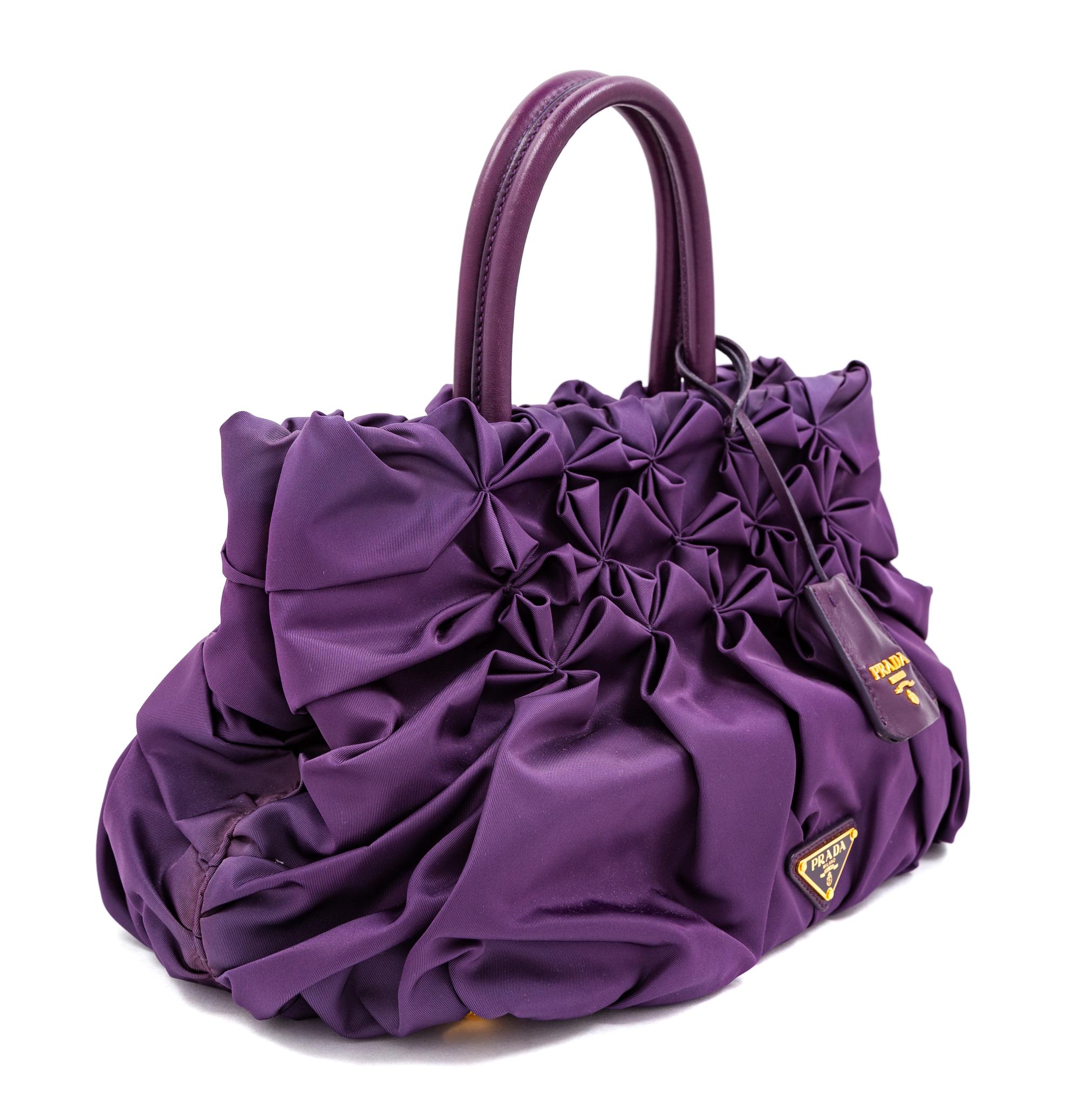 A Prada Purple Tessuto Nylon Origami Handbag with Leather Gloves and Earmuffs, Handbag: 7.5" H x 14" W x 8.25" D; Handle drop: 4.25". G