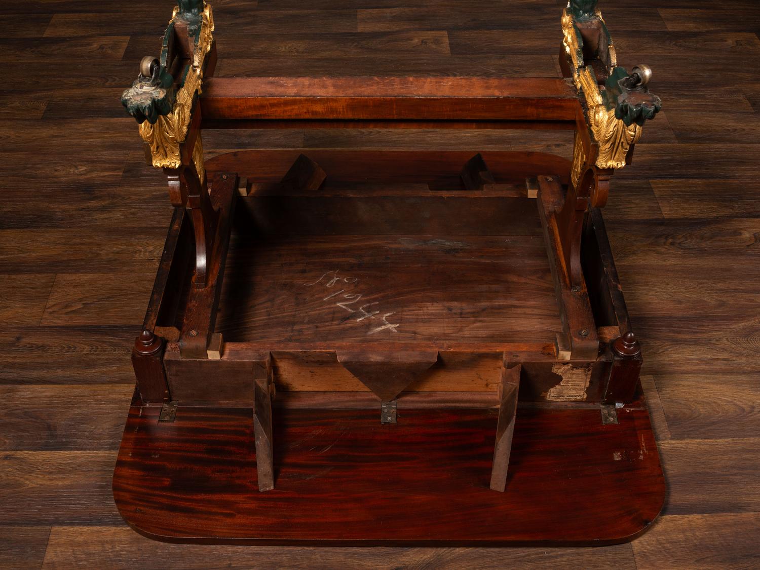 A Classical Parcel Gilt and Ebonized, Figured Mahogany Paw-Foot Drop-Leaf Table