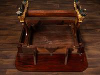 A Classical Parcel Gilt and Ebonized, Figured Mahogany Paw-Foot Drop-Leaf Table