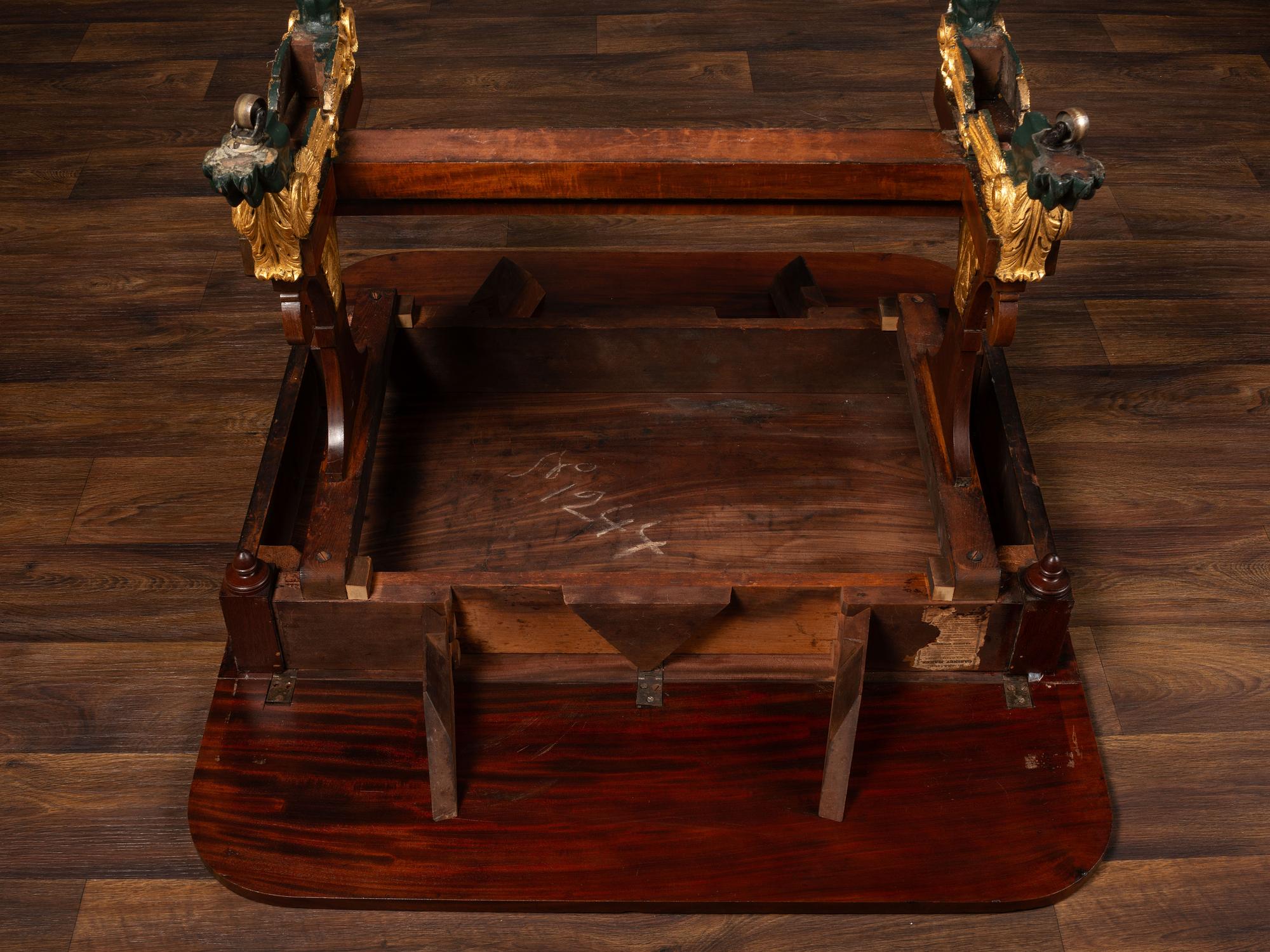 A Classical Parcel Gilt and Ebonized, Figured Mahogany Paw-Foot Drop-Leaf Table