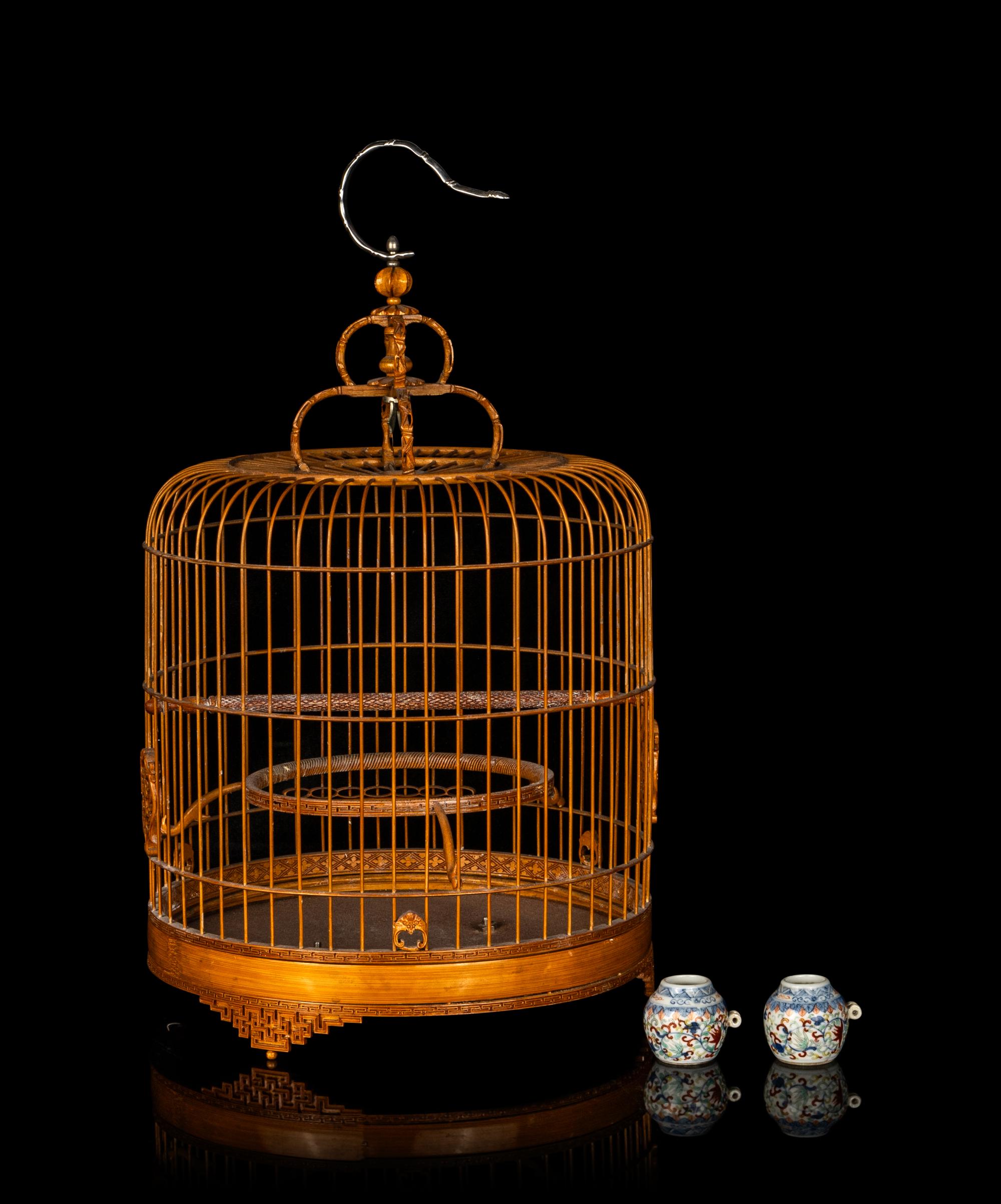 A Chinese Bamboo Bird Cage with A Pair of Wucai Porcelain Bird Feeders