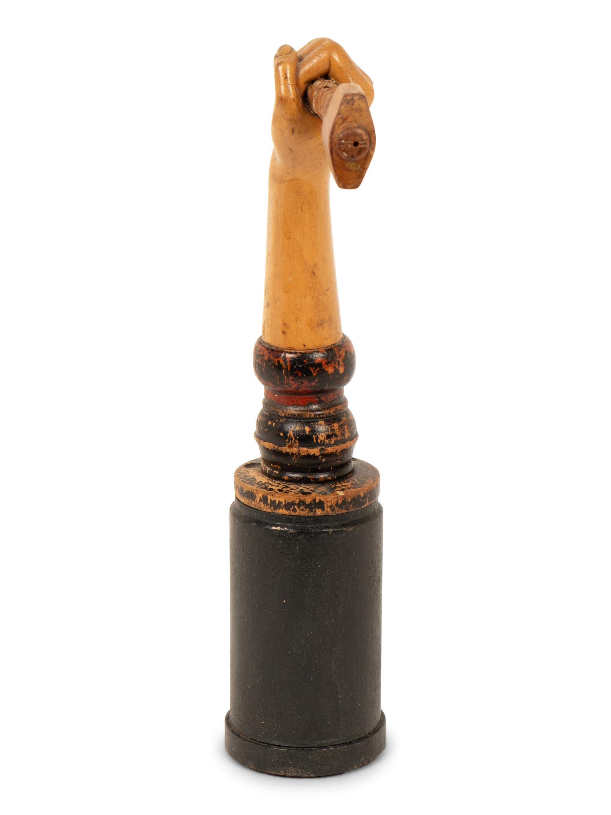 A Folk Art Carved and Polychrome Painted Hand Clutching a Hammer