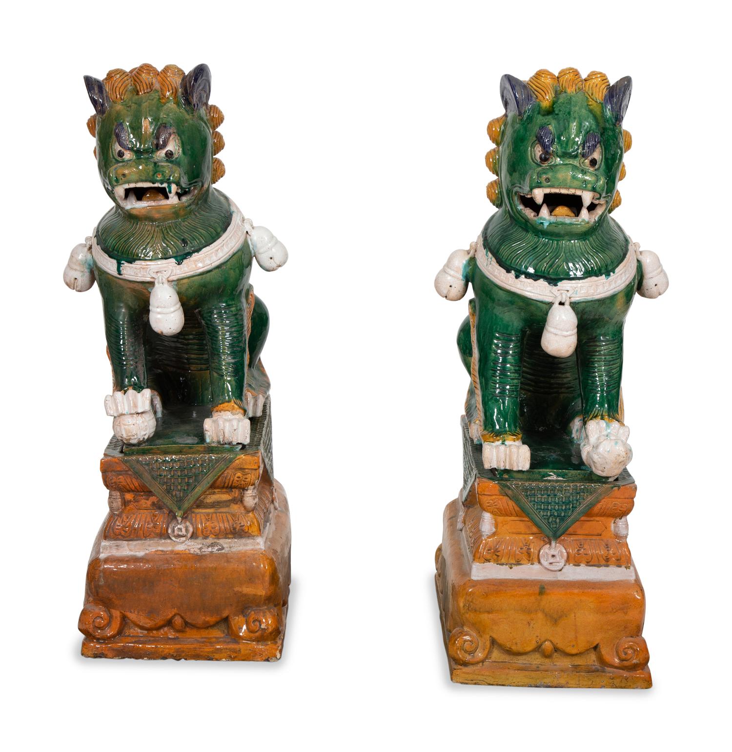 A Pair of Chinese Sançai Glazed Ceramic Guardian Lions on Pedestal Bases