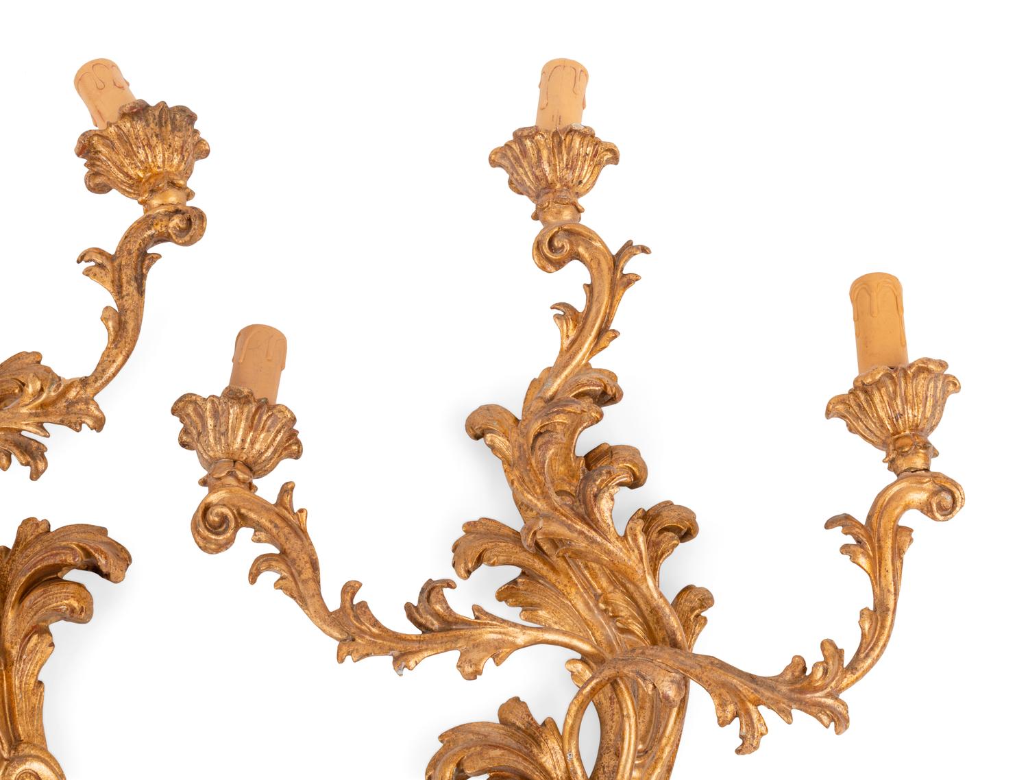 A Set of Four Italian Carved Giltwood Three-Light Sconces