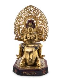 A Gilt and Red Lacquered Bronze Figure of a Multi-Armed Deity