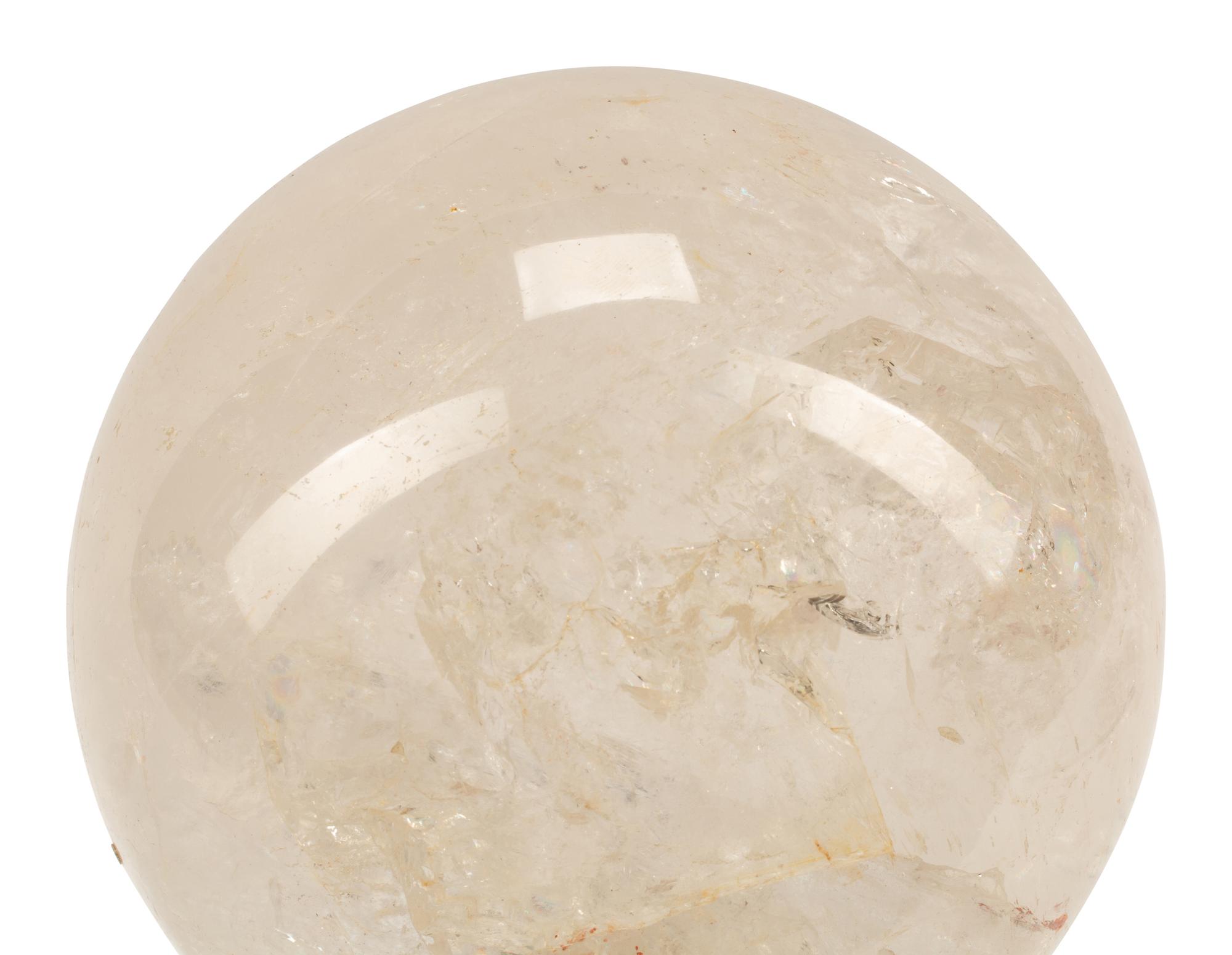 A Rock Crystal Spherical Ornament on a Patinated Bronze Figural Base