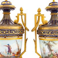 A Pair of Sèvres Style Gilt Bronze Mounted Porcelain Urns