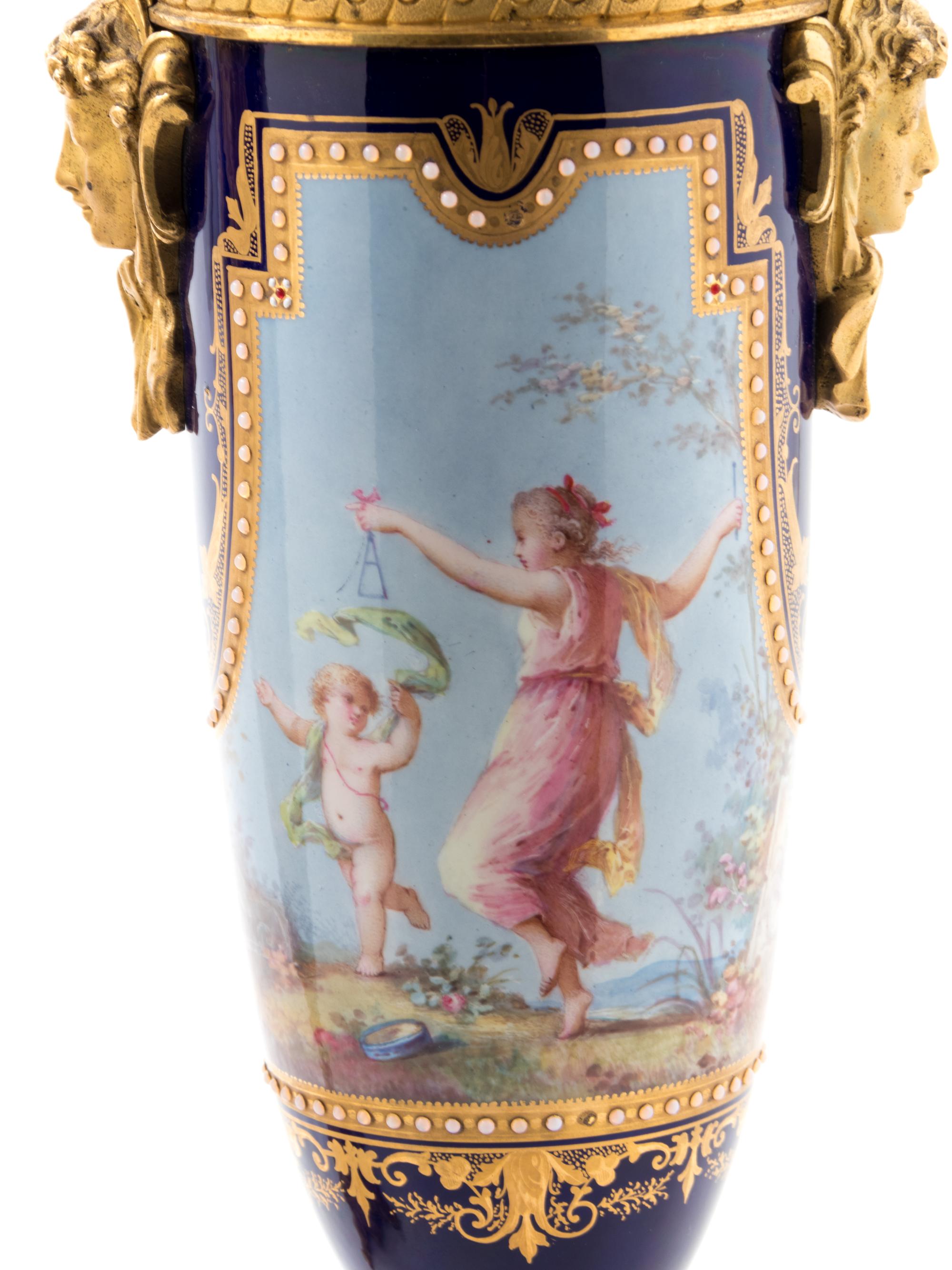 A Pair of Sèvres Style Gilt Bronze Mounted Painted, Parcel Gilt and "Jeweled" Porcelain Urns