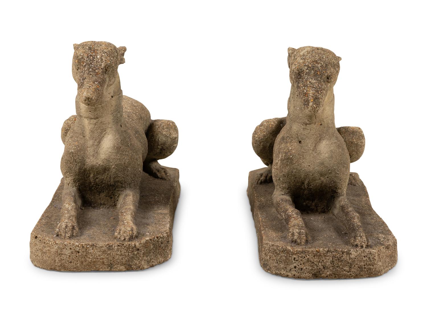 A Pair of Cast Stone Models of Recumbent Dogs