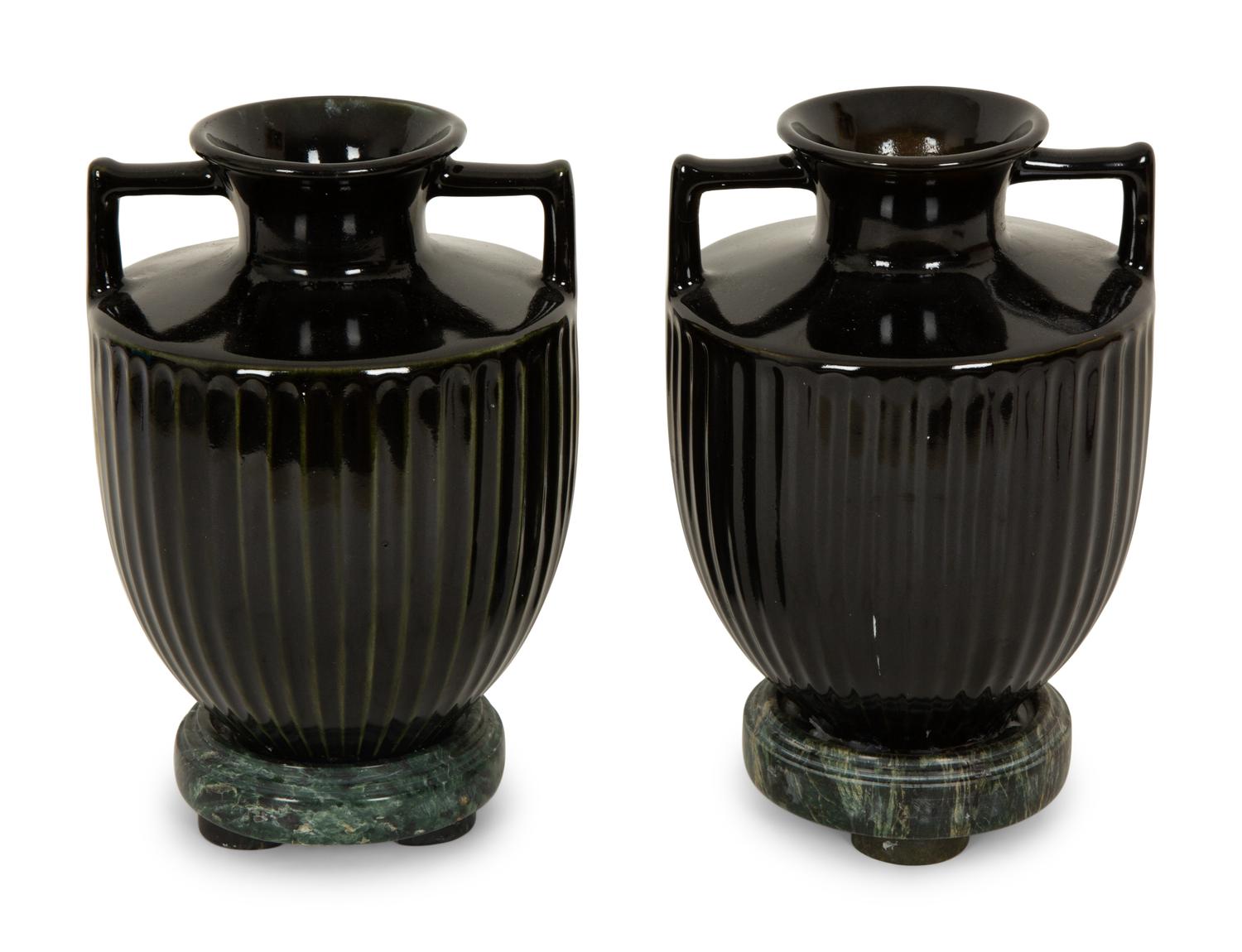 A Pair of Black Porcelain Urns on Green Marbelized Bases