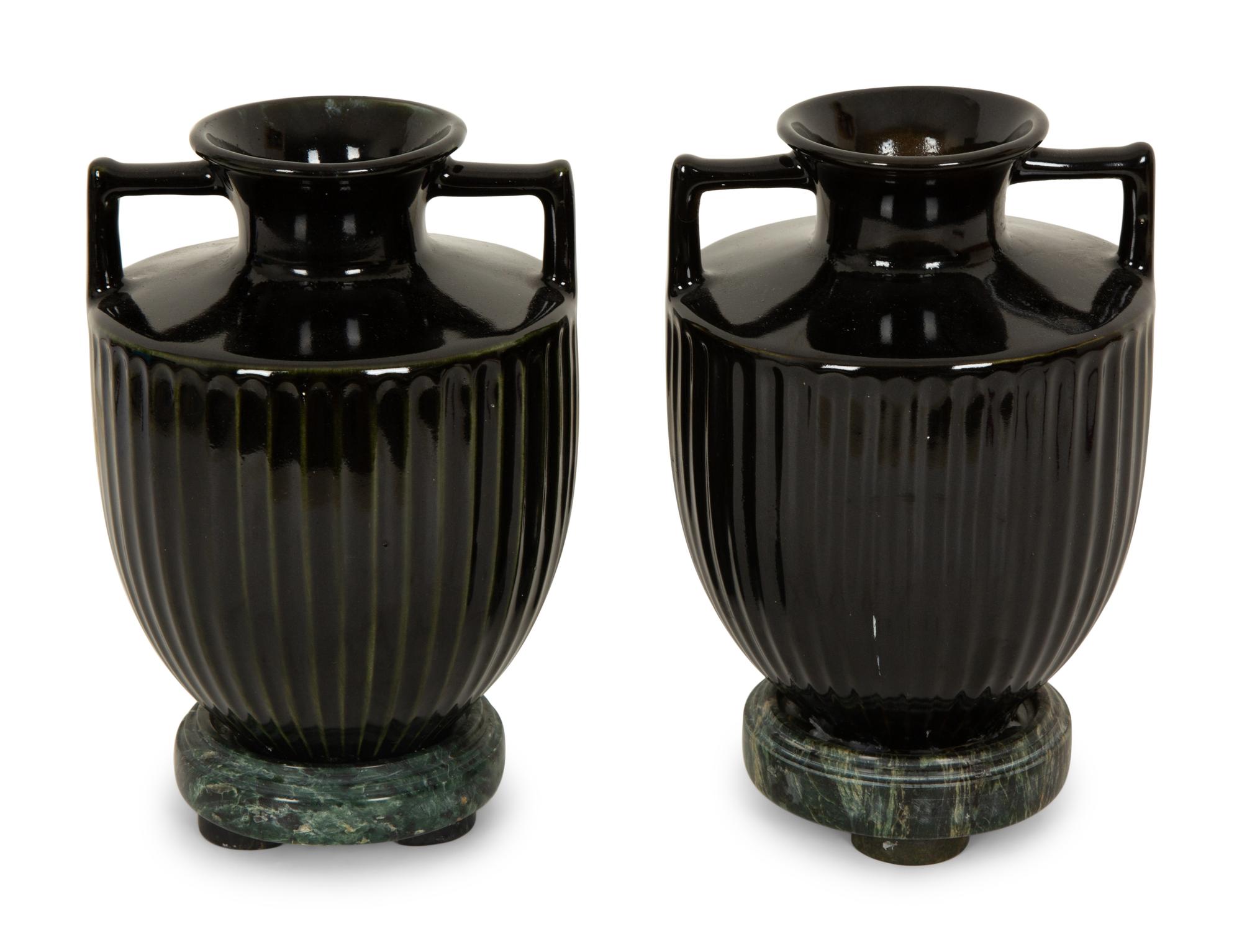 A Pair of Black Porcelain Urns on Green Marbelized Bases