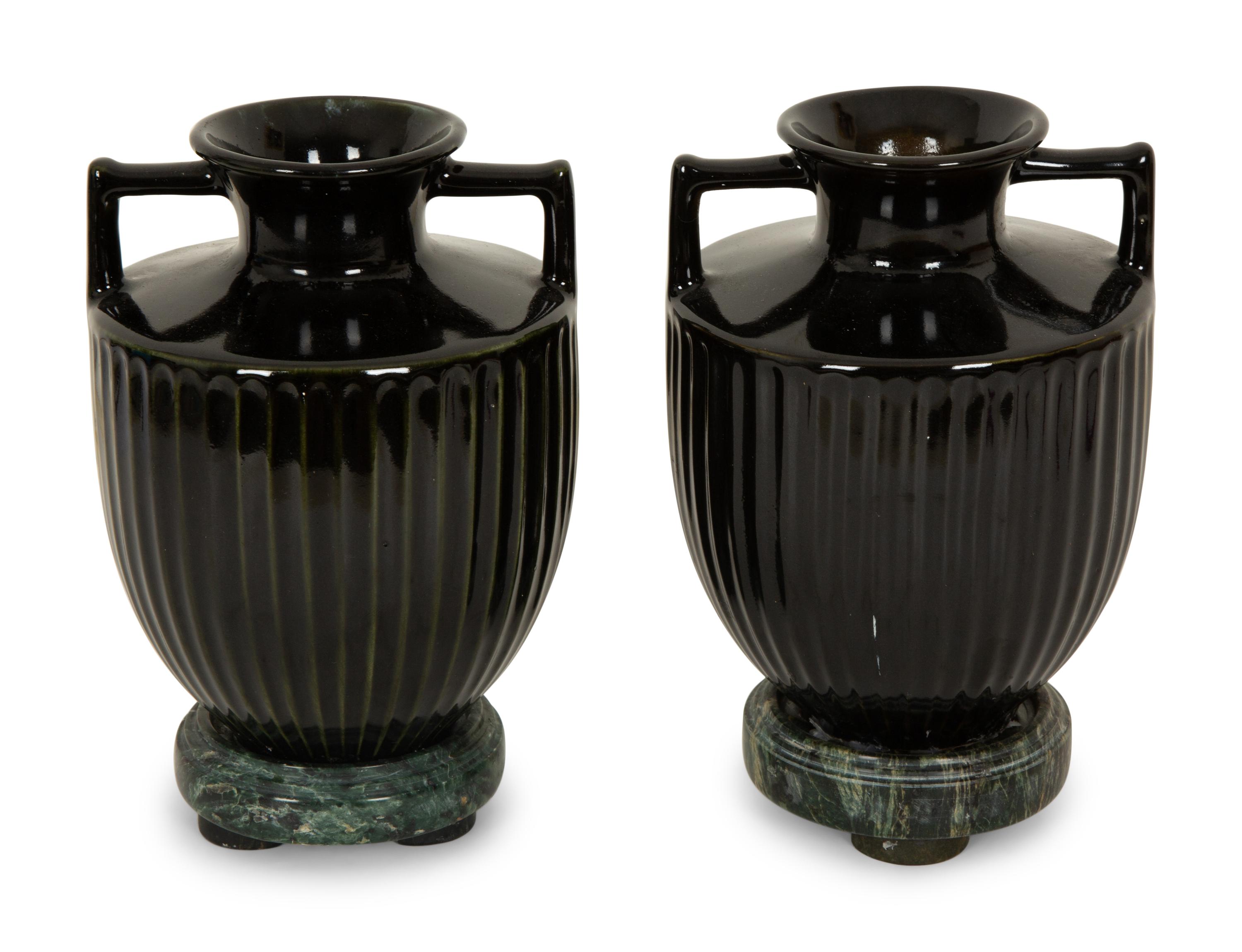 A Pair of Black Porcelain Urns on Green Marbelized Bases
