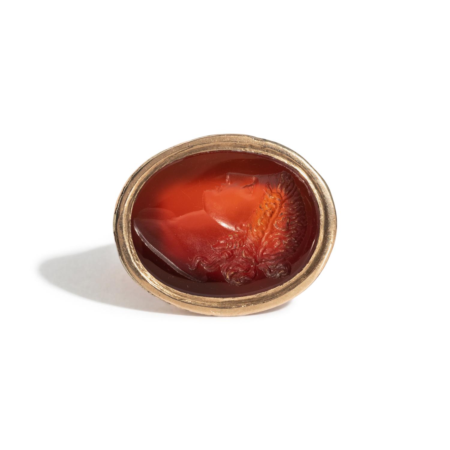 A Neoclassical Carnelian and Brass Finger Ring with a Bust of a Deity