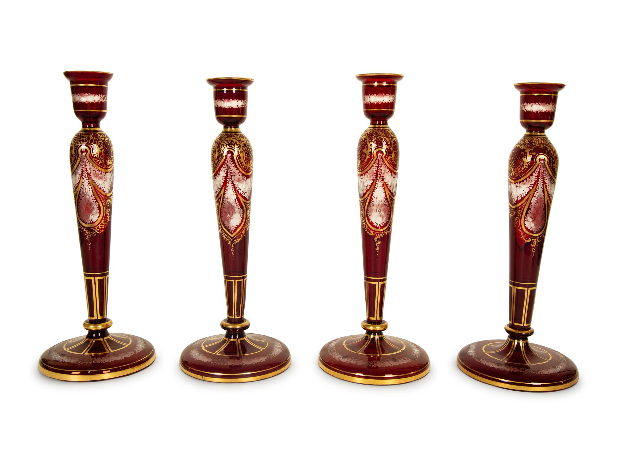 A Set of Four Bohemian Ruby Cut-to-Clear Glass Candlesticks with Gilt Decoration. — 19th Century