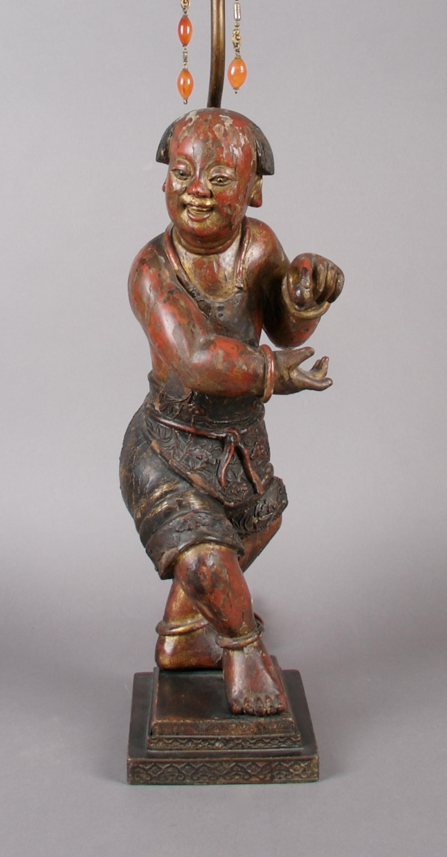 A Red and Brown Lacquered Wood Figure of a Boy, Height of figure 16 inches
