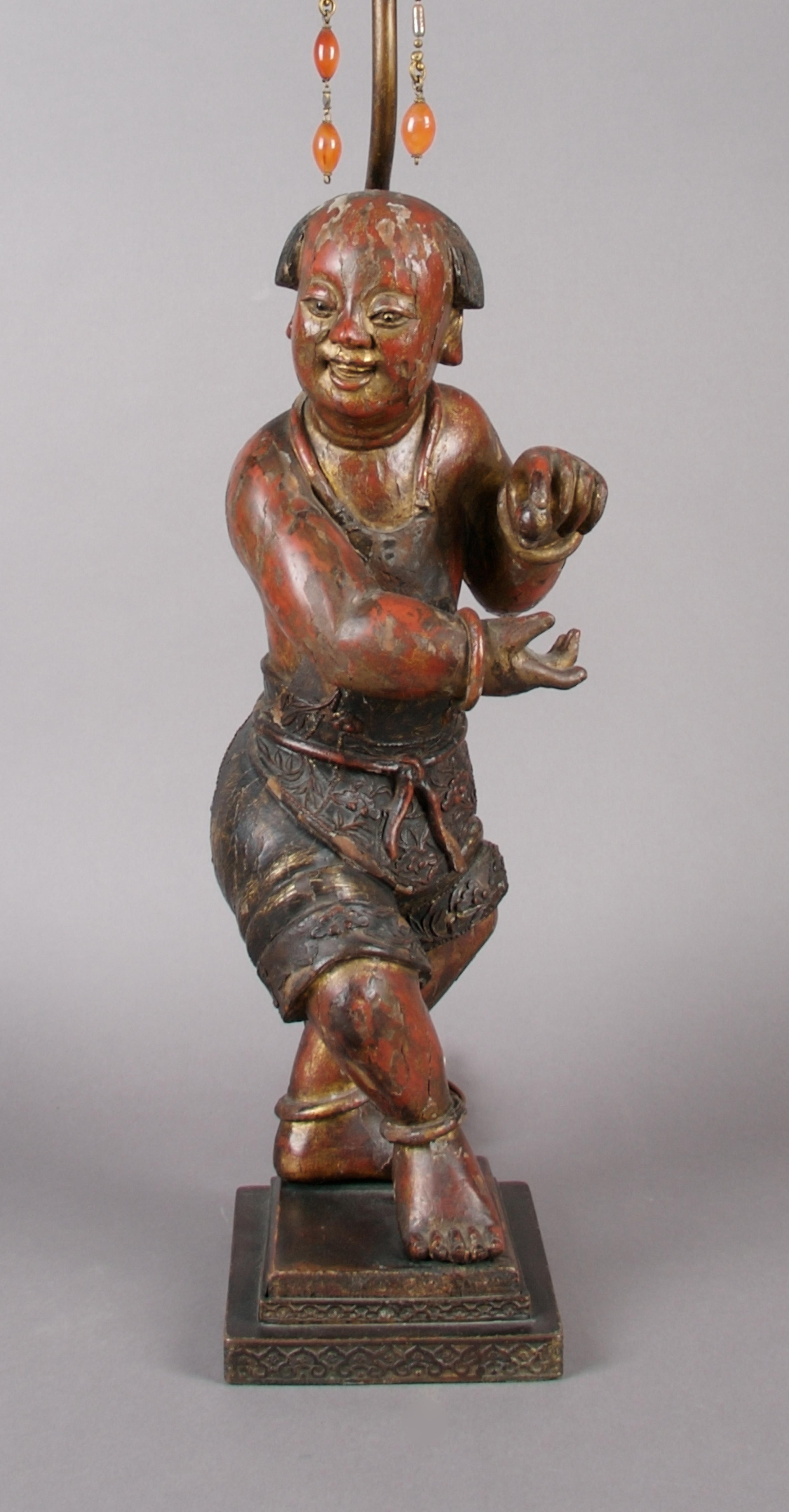A Red and Brown Lacquered Wood Figure of a Boy, Height of figure 16 inches