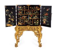 A Chinese Brass-Mounted Gilt-Decorated Black Lacquer Cabinet on Later Giltwood Stand — 18TH/19TH CENTURY