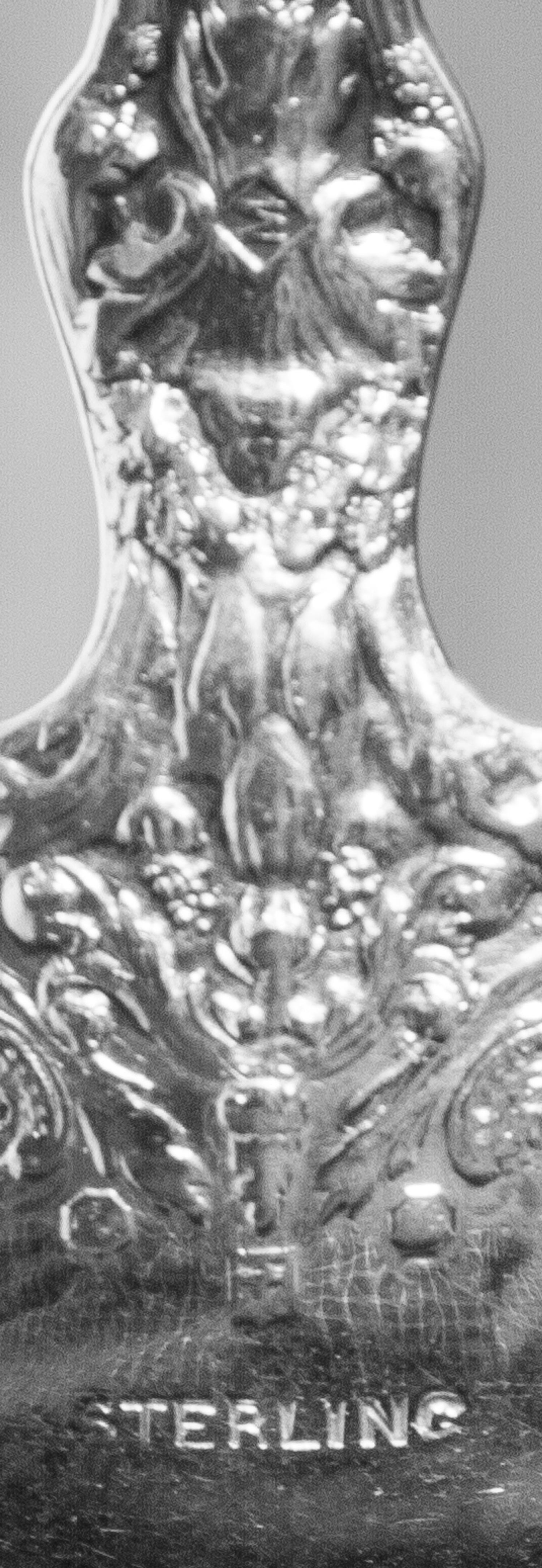 A Set of Twelve American Silver Tablespoons, Maker's Mark M in a Lozenge, each handle decorated with two putti, monogrammed LDG on the