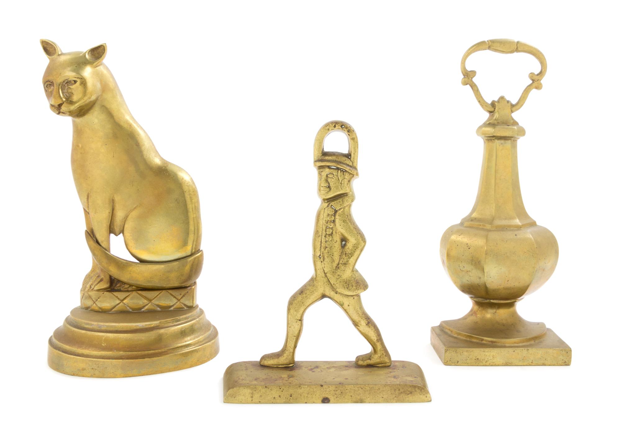Three Brass Doorstops Height of tallest 11 1/2 inches.