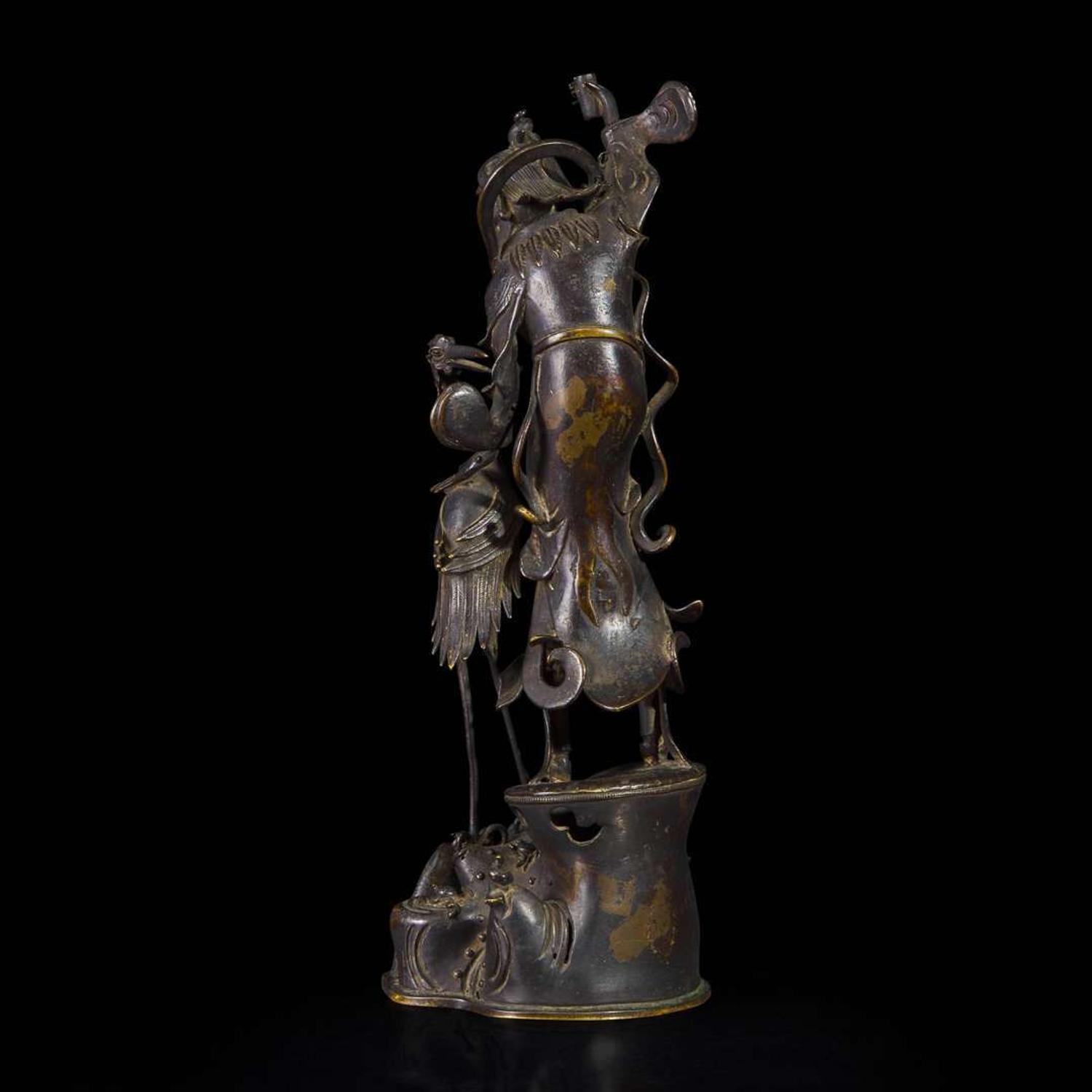 A patinated bronze figure of a Daoist immortal with crane 道教仙人与鹤铜塑 17th century ????