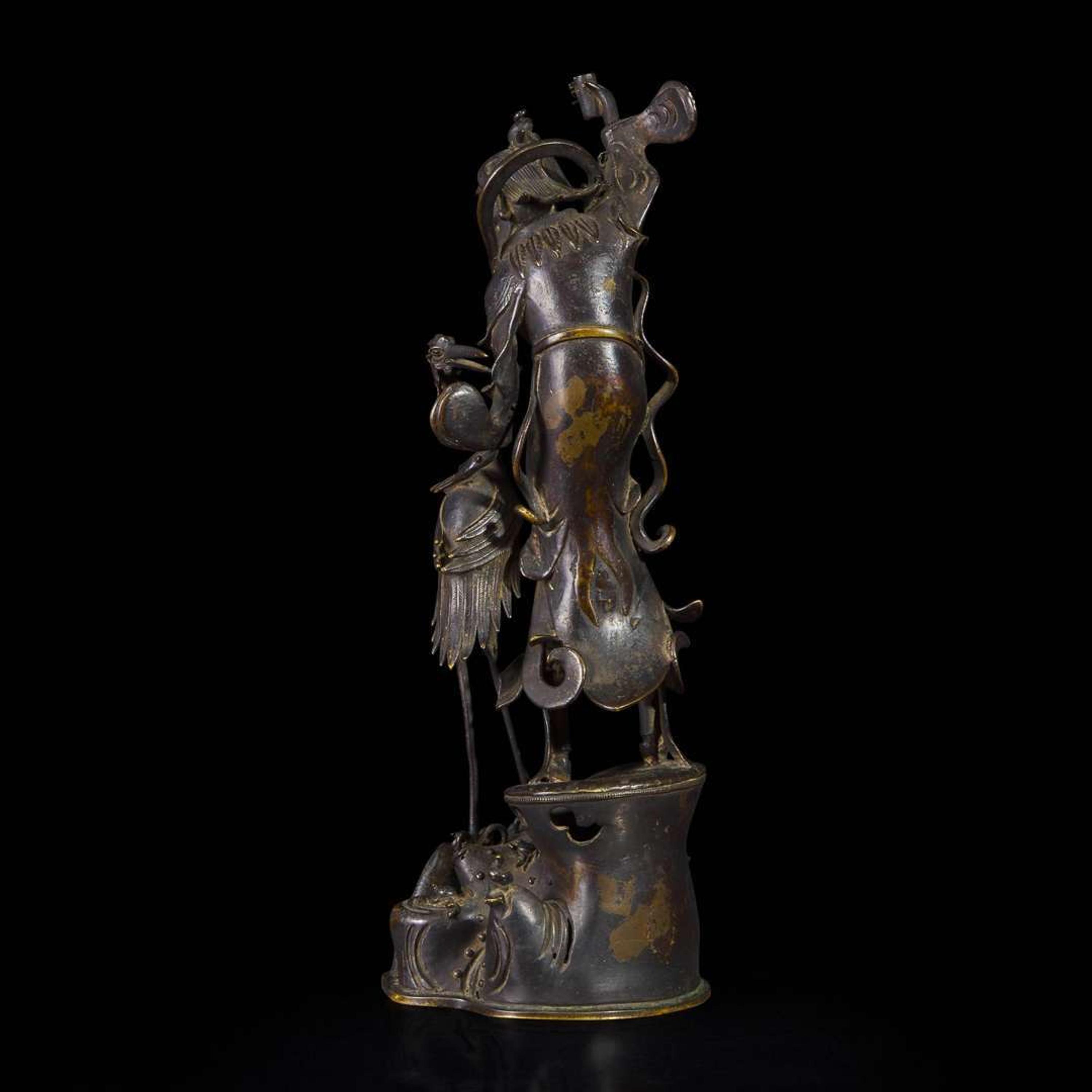 A patinated bronze figure of a Daoist immortal with crane 道教仙人与鹤铜塑 17th century ????