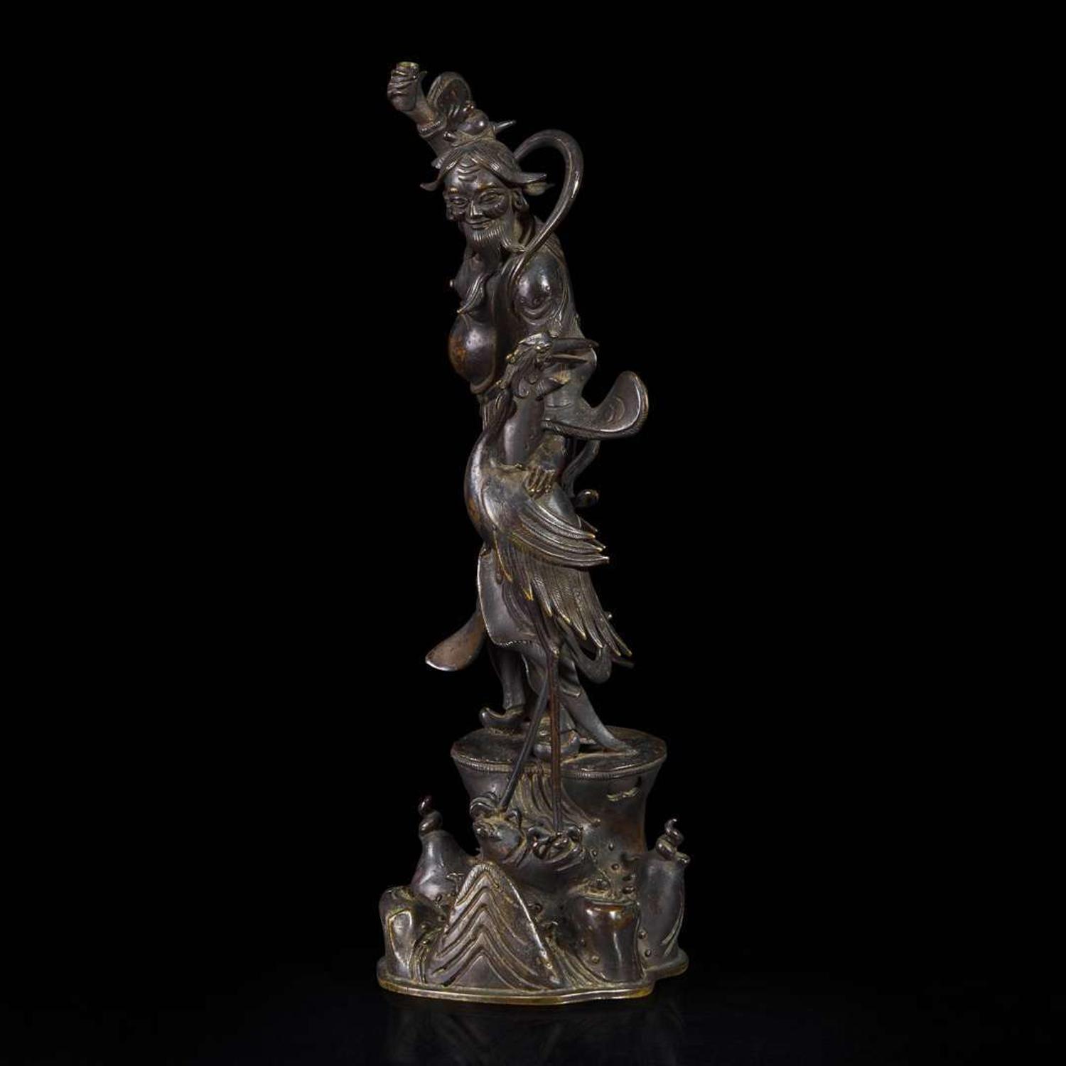 A patinated bronze figure of a Daoist immortal with crane 道教仙人与鹤铜塑 17th century ????