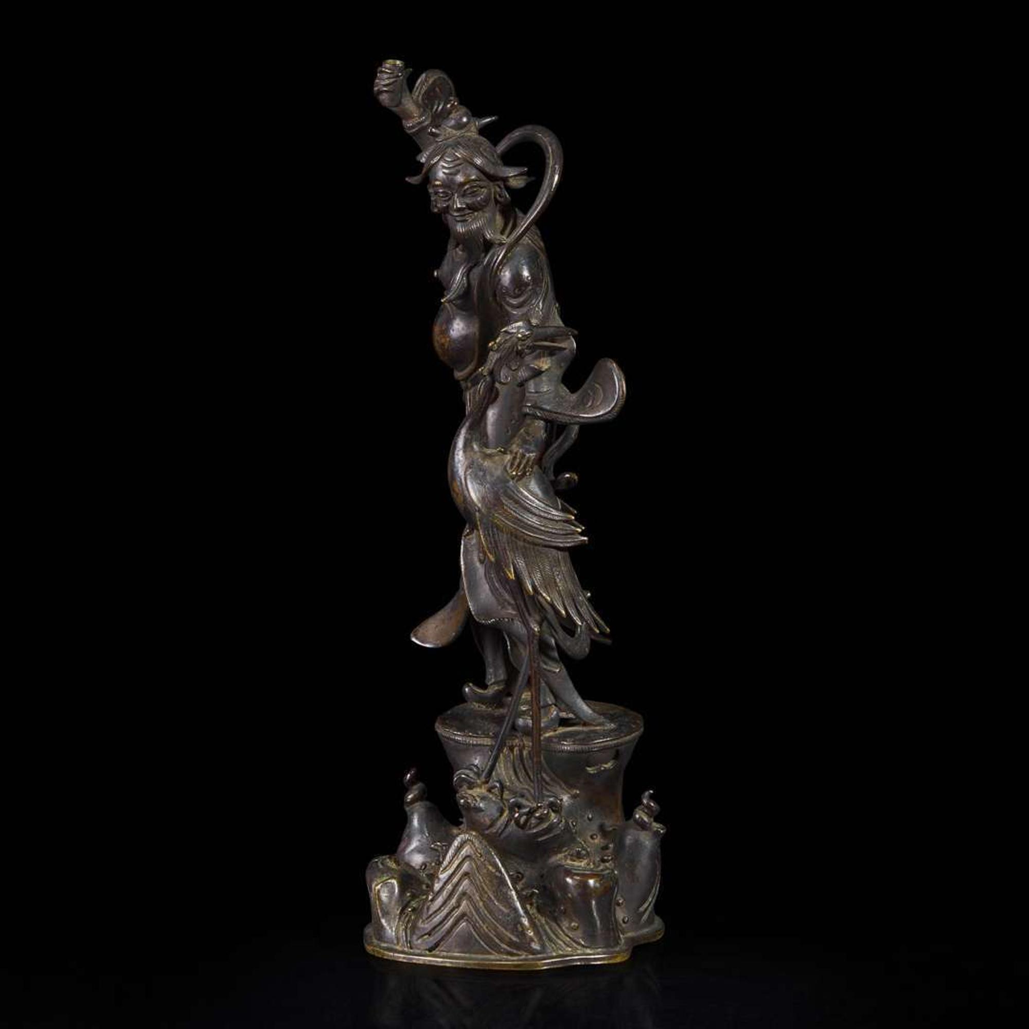 A patinated bronze figure of a Daoist immortal with crane 道教仙人与鹤铜塑 17th century ????