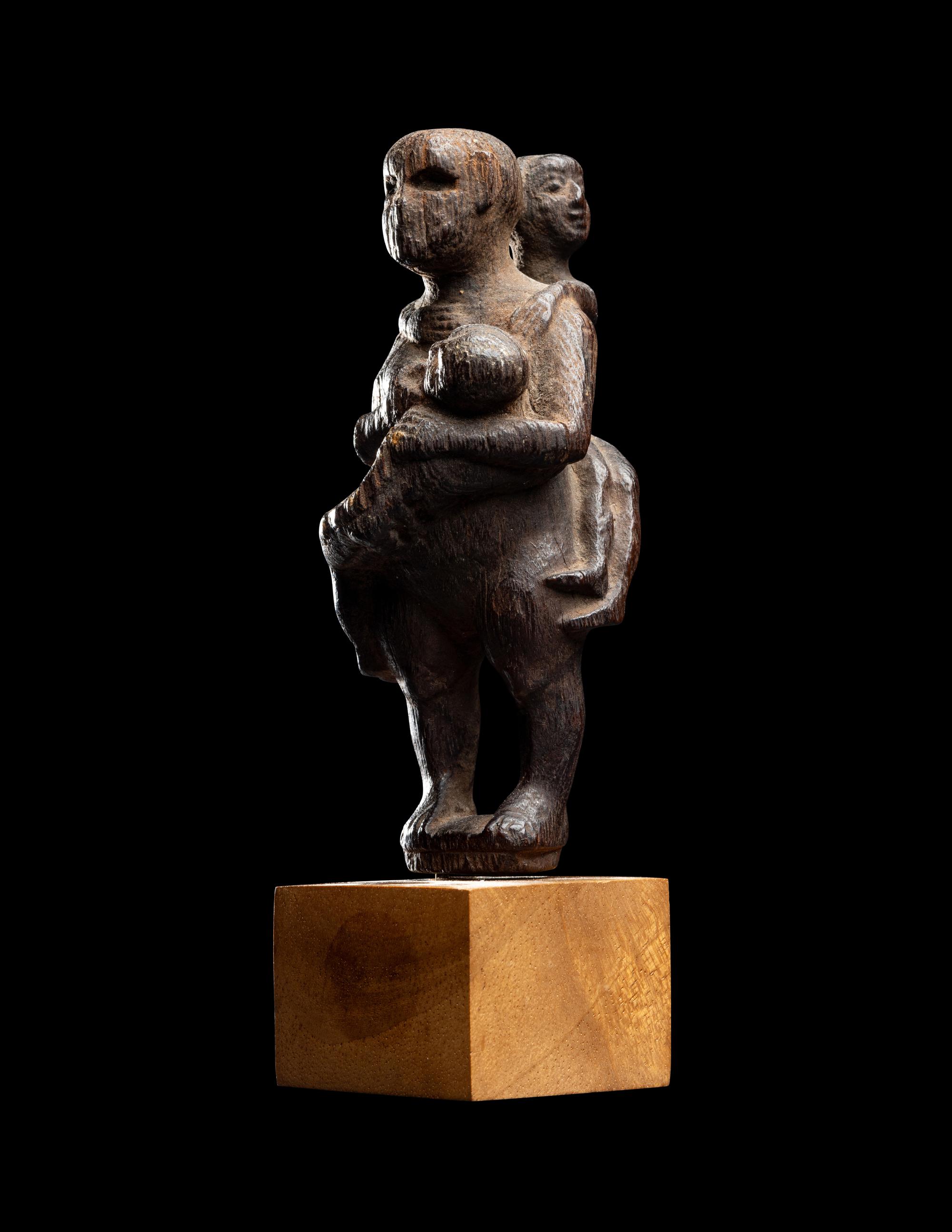 An Egyptian Wood Woman Holding Two Children