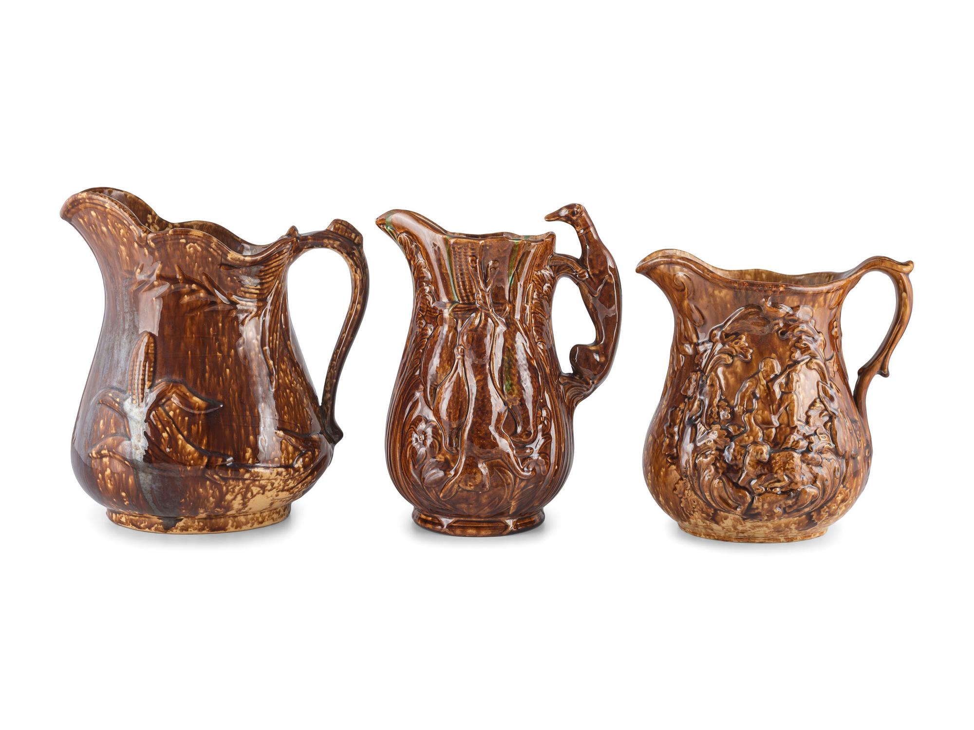 Seven Molded Yellowware Pitchers in Rockingham Glaze