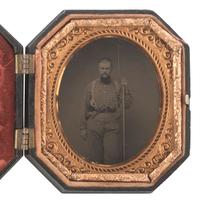 [CIVIL WAR]. Sixth plate tintype of a doubly armed soldier with shaved head, possibly Confederate.