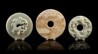 A Group of Seven Carved Jade Bi Discs Diameter of largest 9 inches.