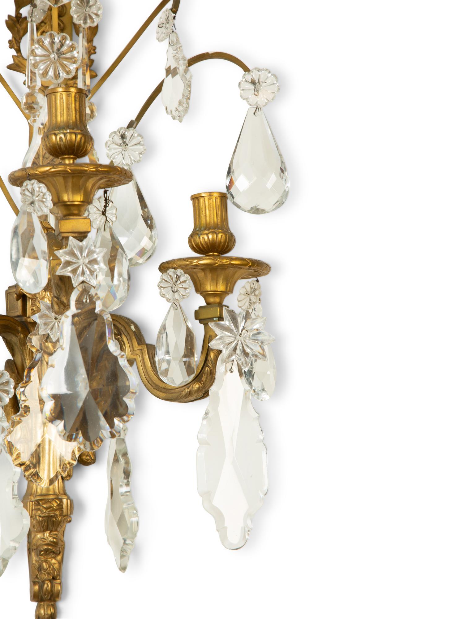 A Pair of Louis XVI Style Gilt Bronze and Cut Glass Three-Light Sconces