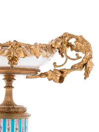 A Pair of Sèvres Style Gilt Bronze Mounted Painted and Parcel Gilt Porcelain Tazze