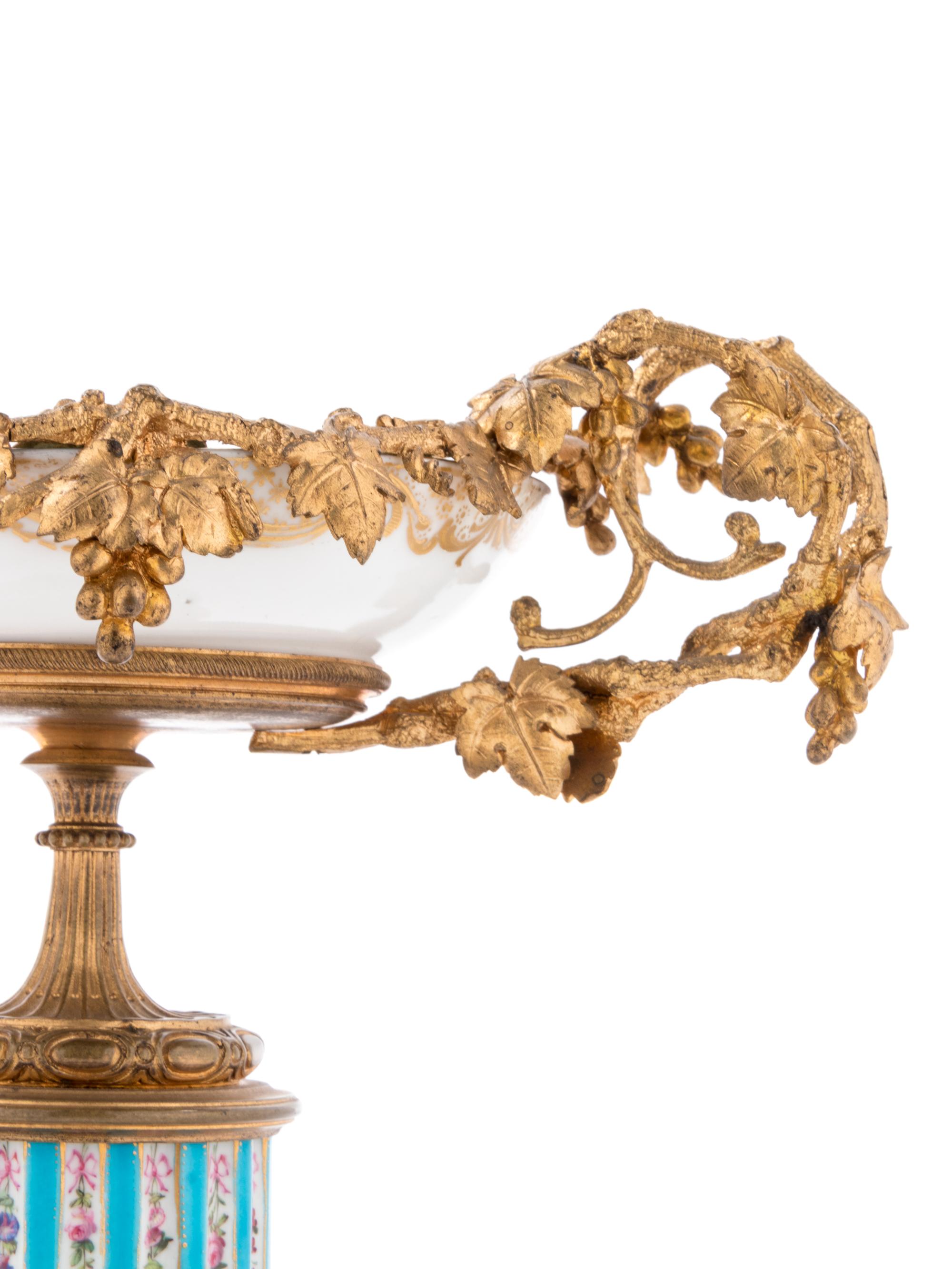 A Pair of Sèvres Style Gilt Bronze Mounted Painted and Parcel Gilt Porcelain Tazze