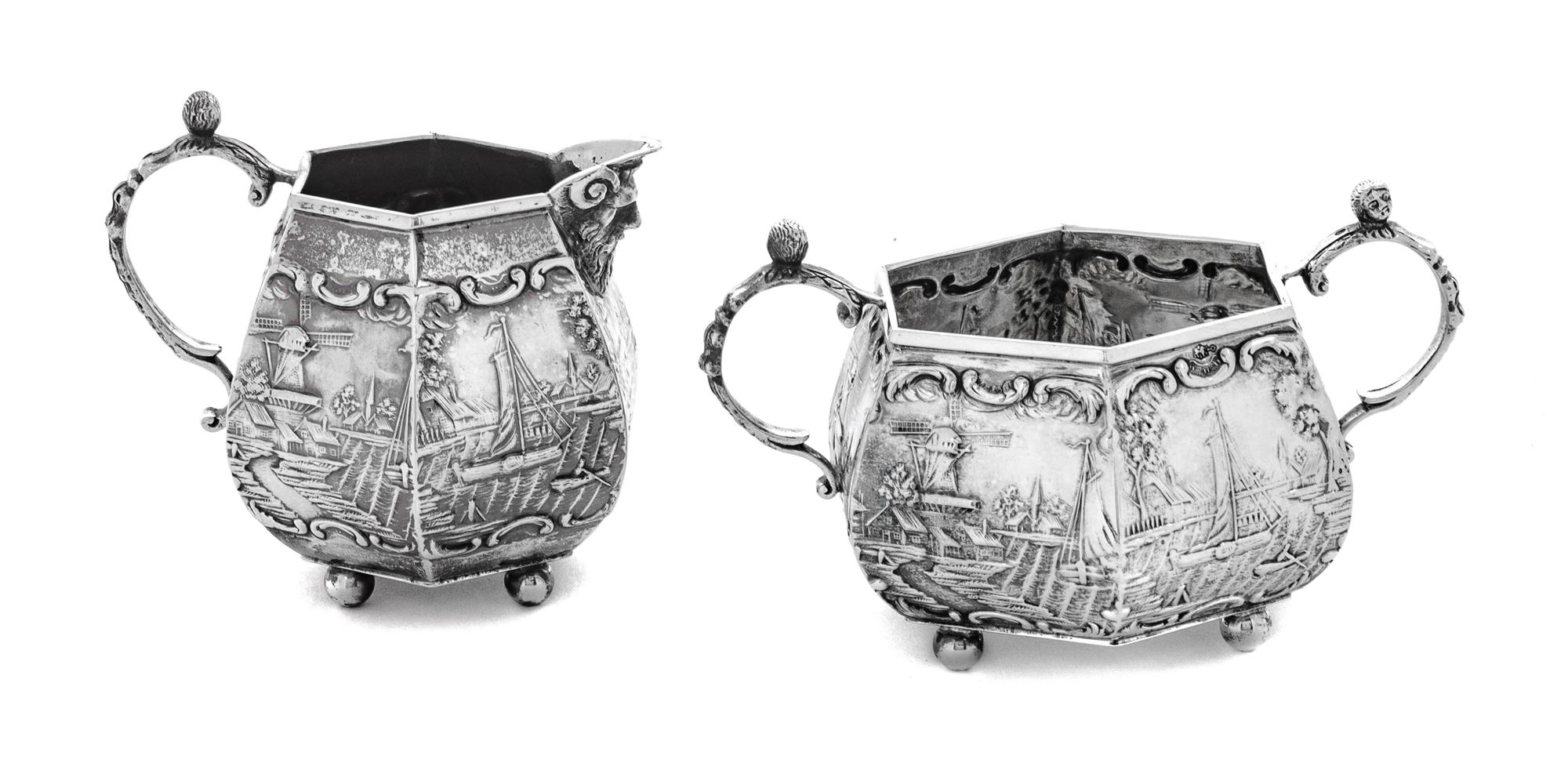 A Dutch Silver Creamer and Sugar Set, , each decorated with nautical scenes.