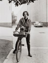 Sid Avery (1918-2002) Audrey Hepburn on her bicycle with her dog "Famous" at Paramount Studios, Los Angeles, CA, 1957