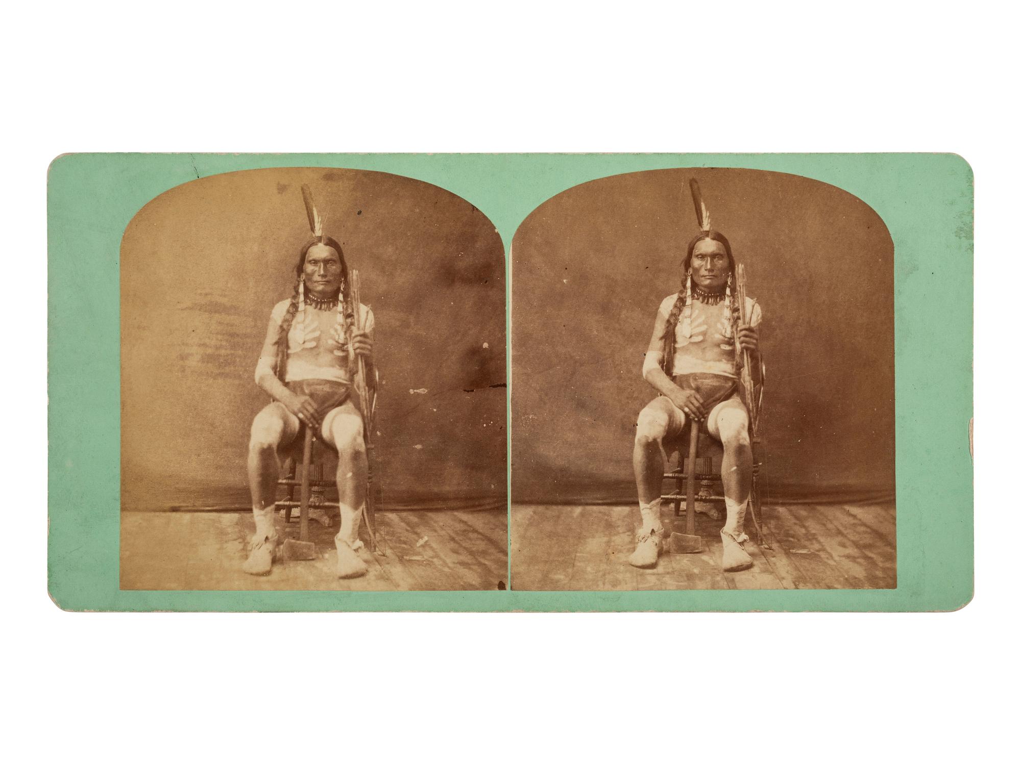 [NATIVE AMERICANS]. MORROW, Stanley J. (1843-1921), photographer. Stereoview of a Sioux subject with tomahawk and arrows.