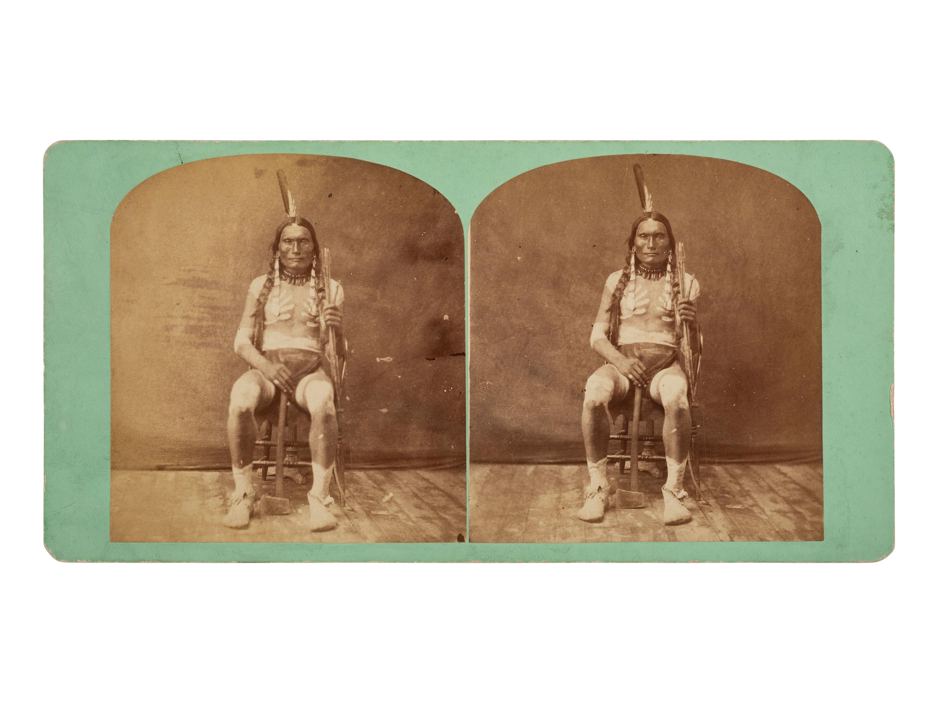 [NATIVE AMERICANS]. MORROW, Stanley J. (1843-1921), photographer. Stereoview of a Sioux subject with tomahawk and arrows.