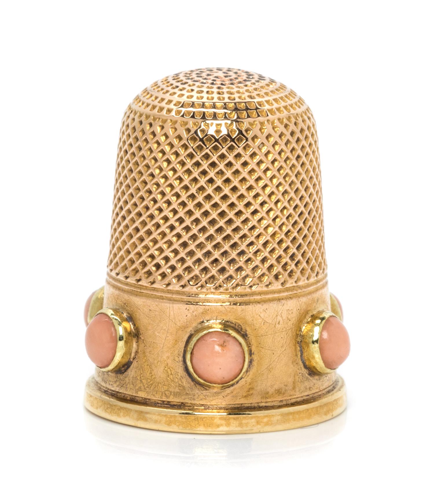 An English Yellow Gold and Coral Thimble, , the knurled top and body above a plain band inset with six coral cabochons.