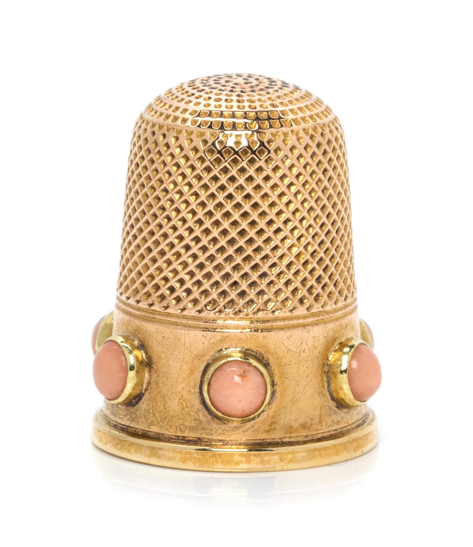 An English Yellow Gold and Coral Thimble, , the knurled top and body above a plain band inset with six coral cabochons.