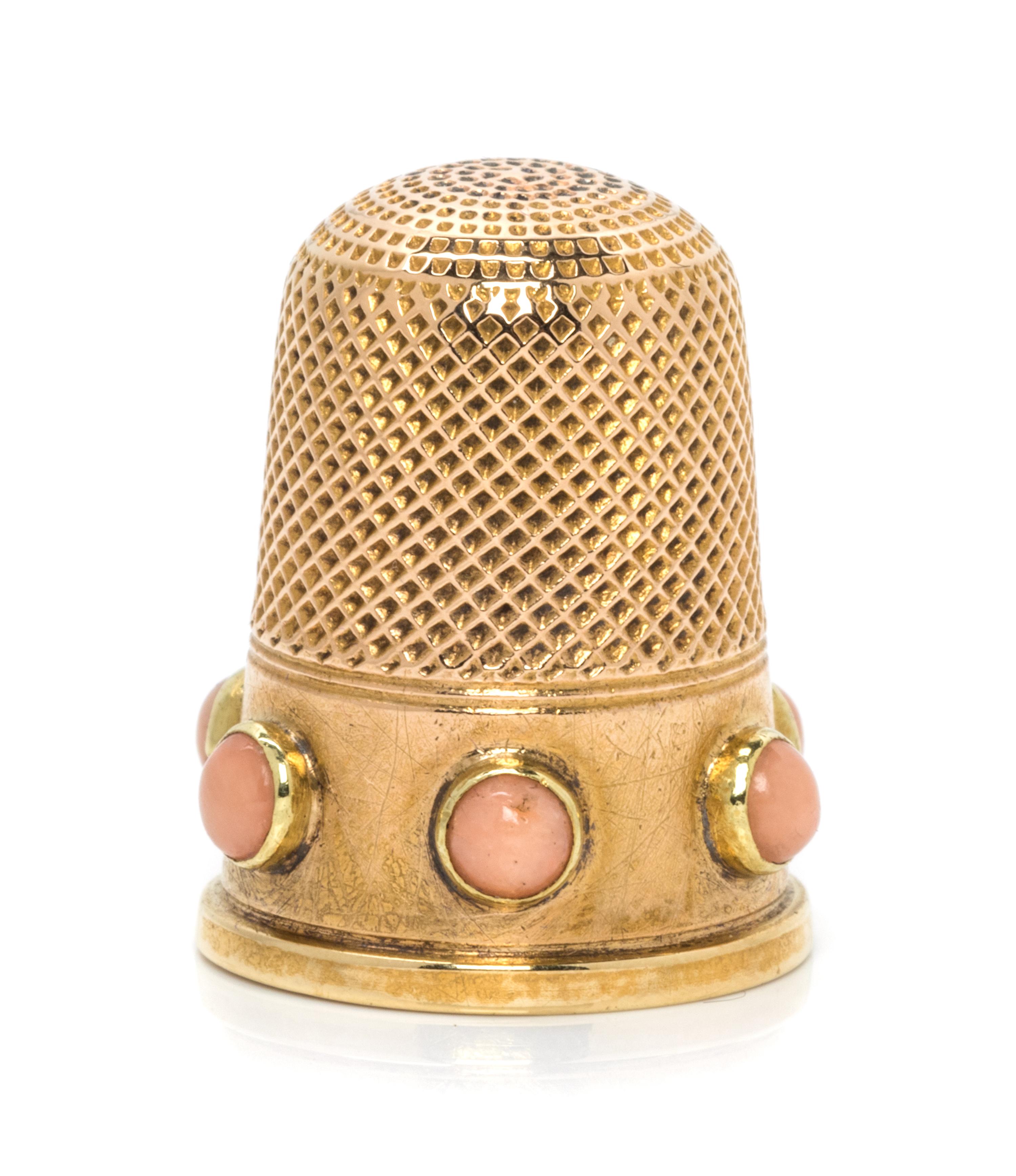 An English Yellow Gold and Coral Thimble, , the knurled top and body above a plain band inset with six coral cabochons.