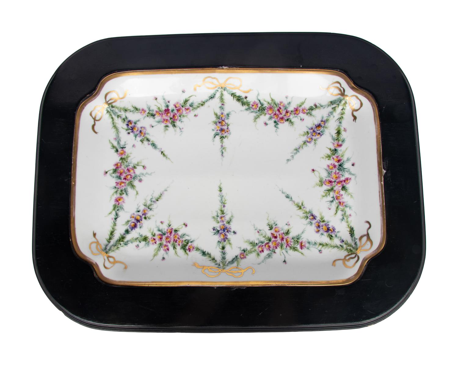 A German Porcelain Tray Set in a Later Ebonized Side Table
