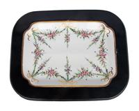 A German Porcelain Tray Set in a Later Ebonized Side Table