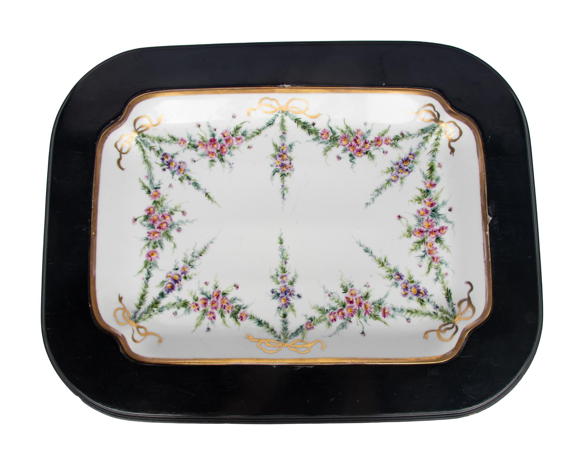 A German Porcelain Tray Set in a Later Ebonized Side Table