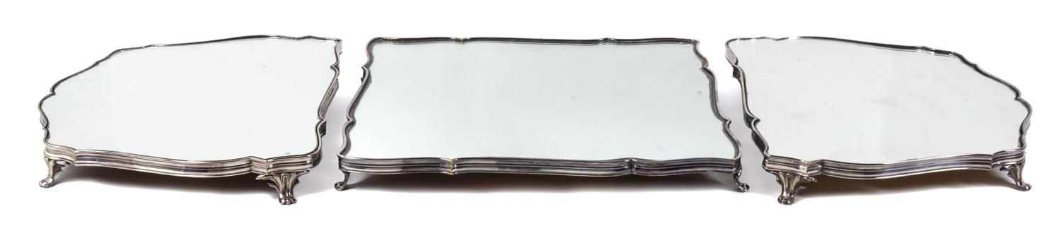 A French Silver-Plate Surtout de Table, Christofle & Cie, Paris, in three parts, each mirrored and raised on four foliate scroll feet.
